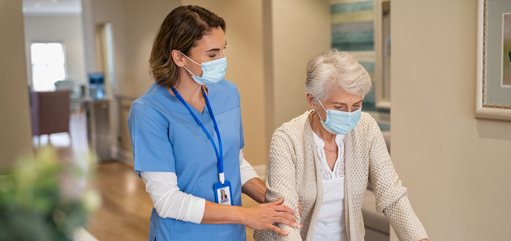 Nurse helping senior woman walk at nursing home